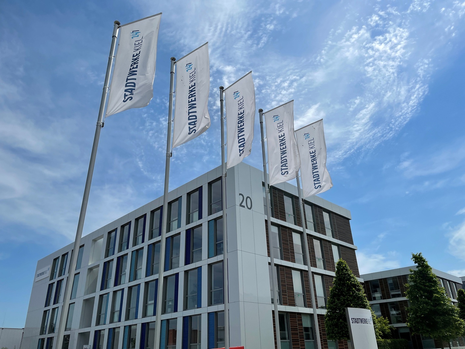 Die SWKiel Netz GmbH ist ein Unternehmen der Stadtwerke Kiel AG. Abgebildet ist das Hauptgebäude mit Fahnen davor.
